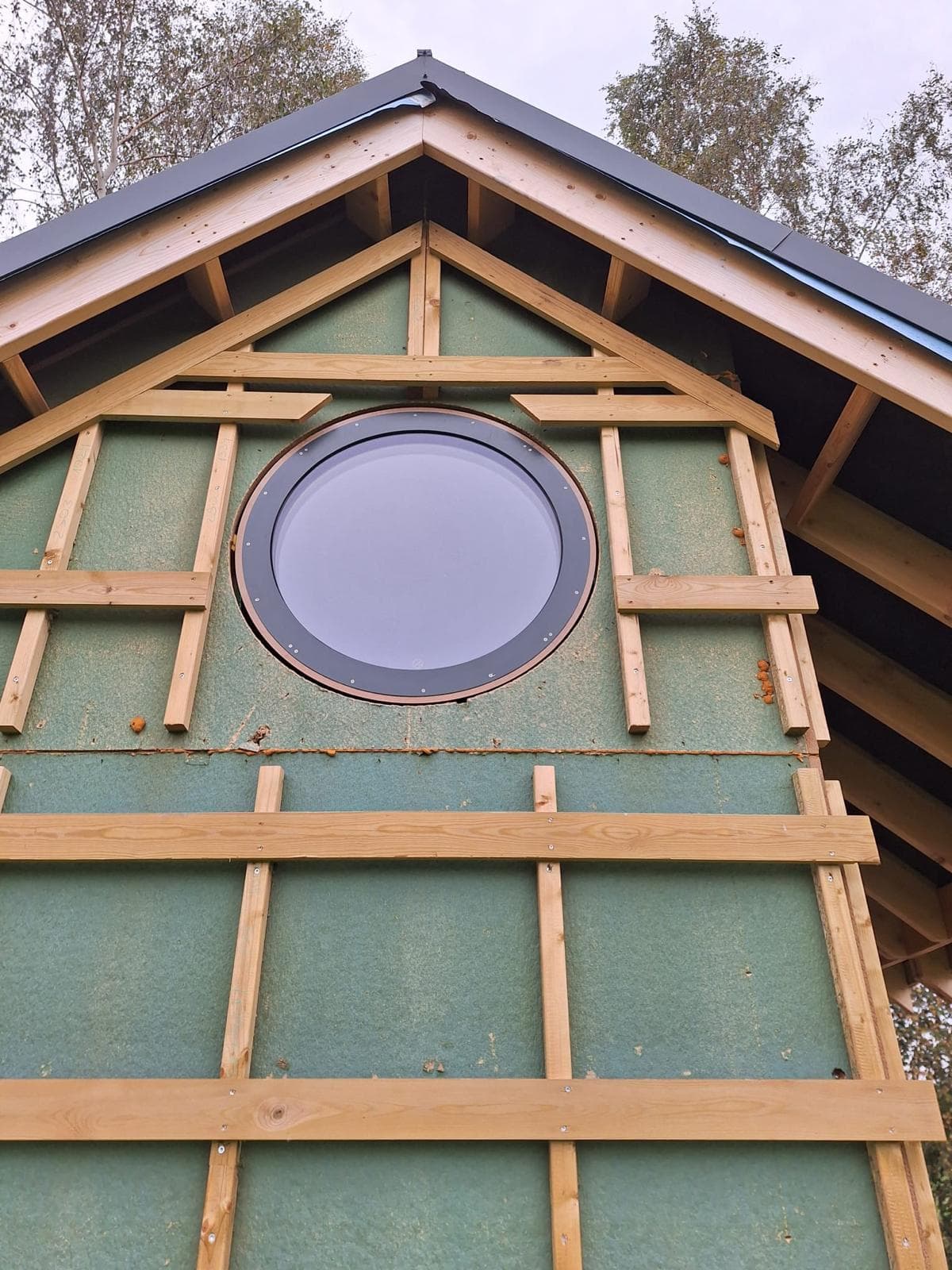 O360 round window installed in gable with dark exterior trim